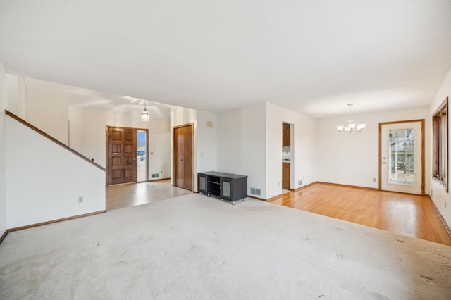 unfurnished living room with light carpet and an inviting chandelier