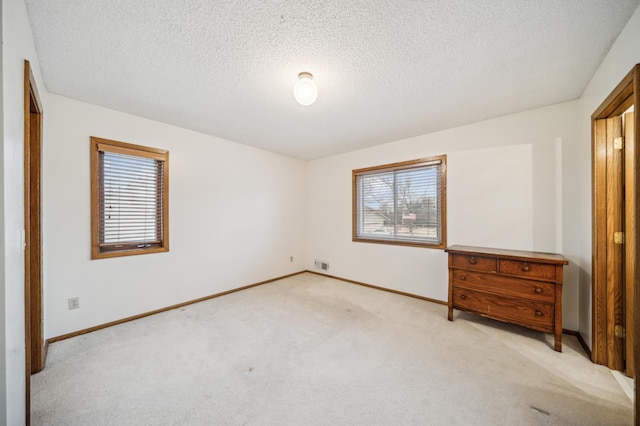 carpeted bedroom with multiple windows and a textured ceiling