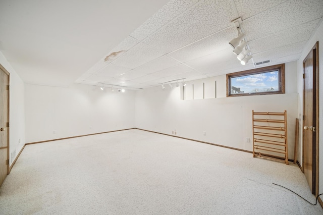 basement with track lighting and carpet flooring