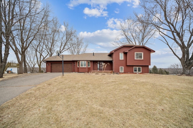 tri-level home with a garage and a front lawn