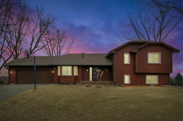 tri-level home with a yard and a garage