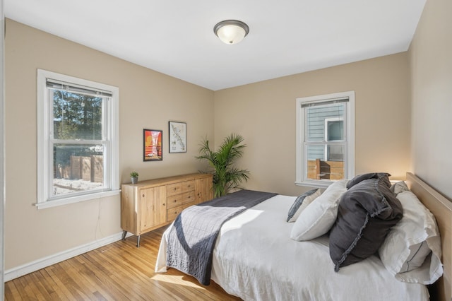 bedroom with light wood-style flooring and baseboards