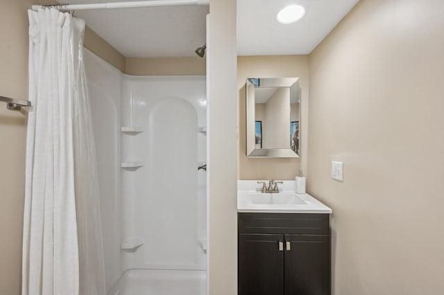 bathroom featuring a stall shower and vanity