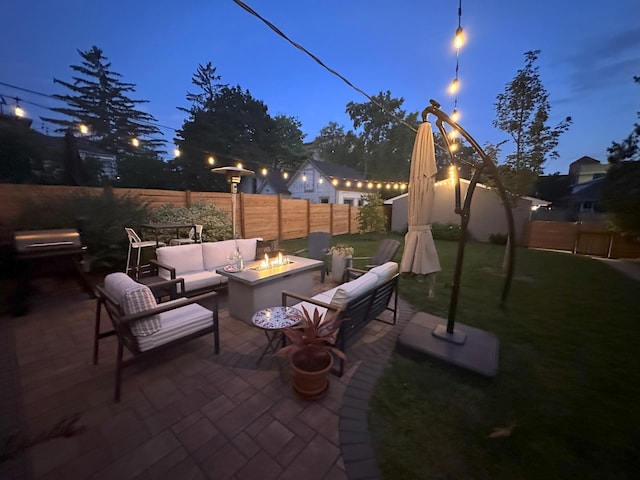 patio terrace at dusk with a yard, a fenced backyard, and an outdoor living space with a fire pit