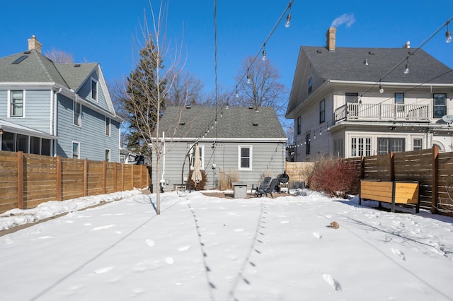 snow covered property featuring entry steps and fence