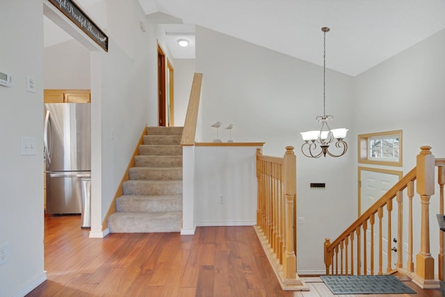 stairs featuring hardwood / wood-style floors, a chandelier, and a high ceiling