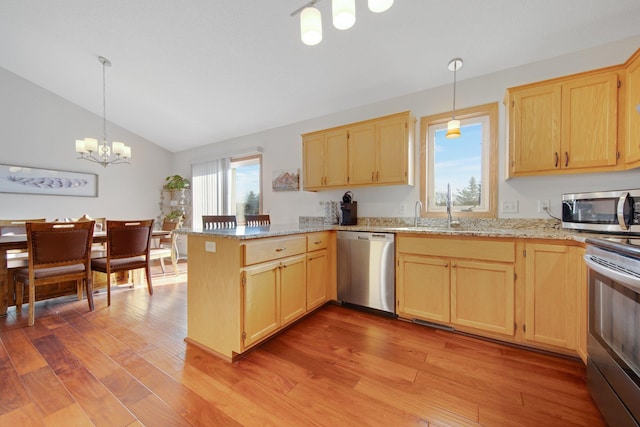 kitchen with pendant lighting, appliances with stainless steel finishes, kitchen peninsula, and light hardwood / wood-style flooring