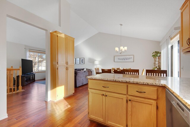 kitchen with lofted ceiling, dishwasher, hanging light fixtures, hardwood / wood-style floors, and light brown cabinets