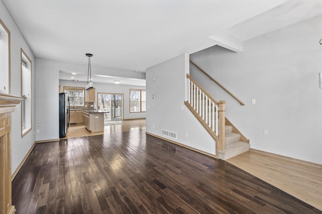 unfurnished living room with dark wood-type flooring