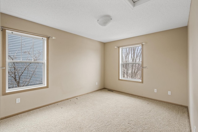 carpeted spare room with a textured ceiling