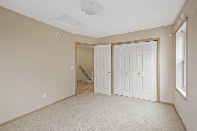 unfurnished bedroom with light colored carpet, a closet, and multiple windows