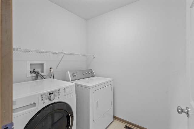 laundry area featuring washer and clothes dryer and a textured ceiling