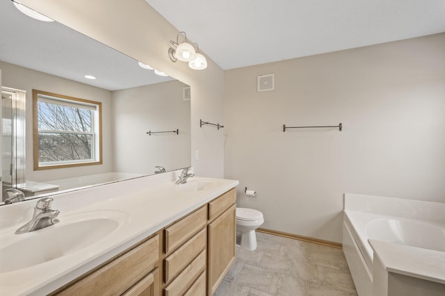 bathroom featuring vanity, toilet, and a washtub