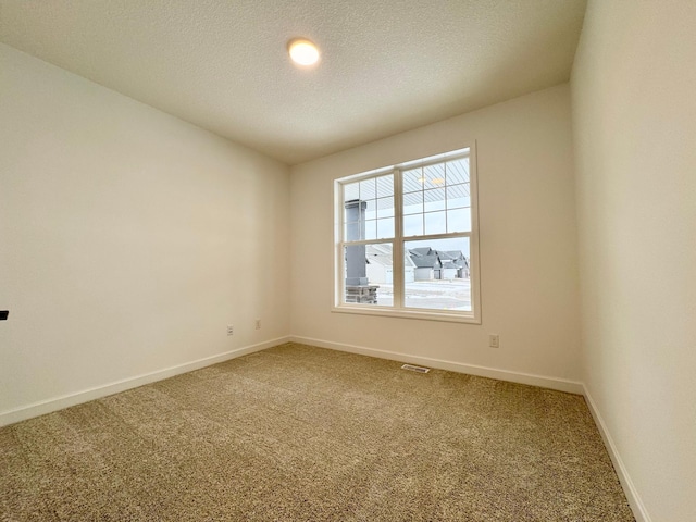 carpeted empty room with a textured ceiling