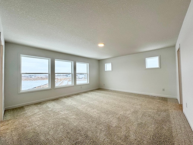 carpeted empty room featuring a textured ceiling