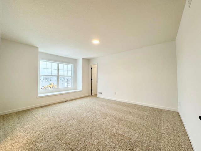 carpeted spare room featuring a textured ceiling