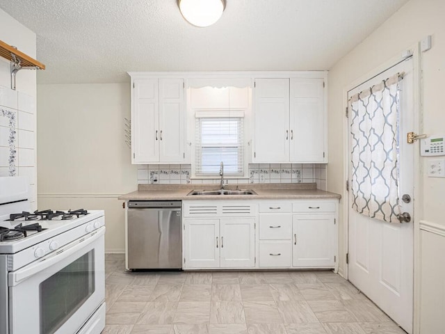 kitchen featuring sink, white cabinetry, stainless steel dishwasher, white range with gas cooktop, and backsplash