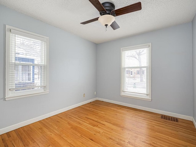 unfurnished room featuring ceiling fan, light hardwood / wood-style flooring, and a textured ceiling