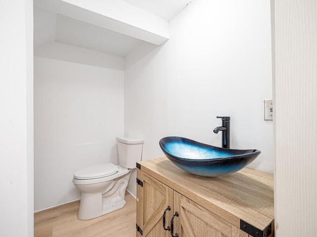 bathroom featuring wood-type flooring, toilet, and vanity