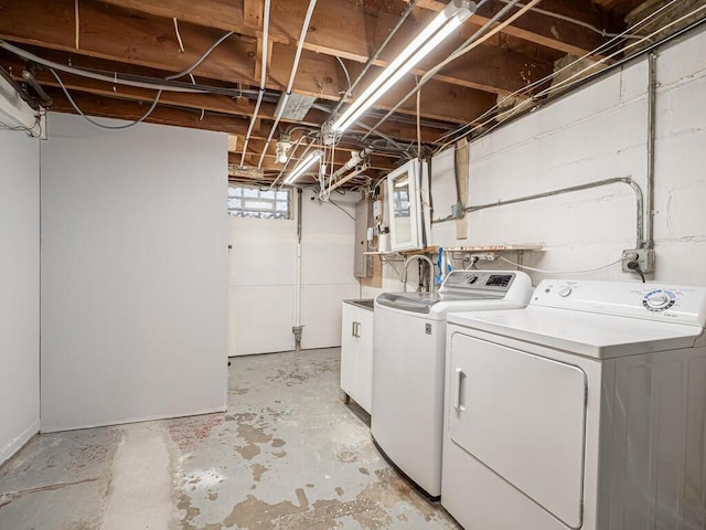 clothes washing area featuring independent washer and dryer and cabinets