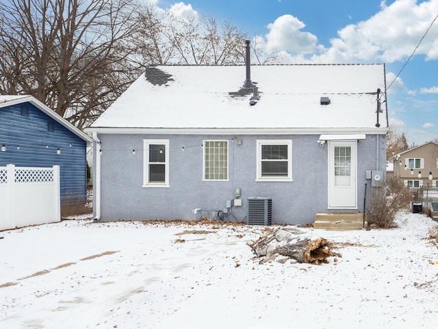 snow covered house featuring central AC