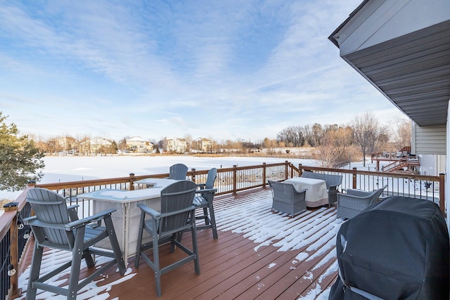 snow covered deck with grilling area and a bar