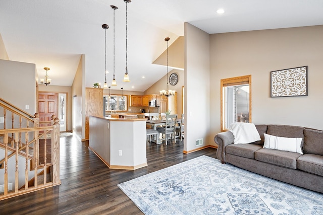 living room with a chandelier, stairs, visible vents, and dark wood-style floors