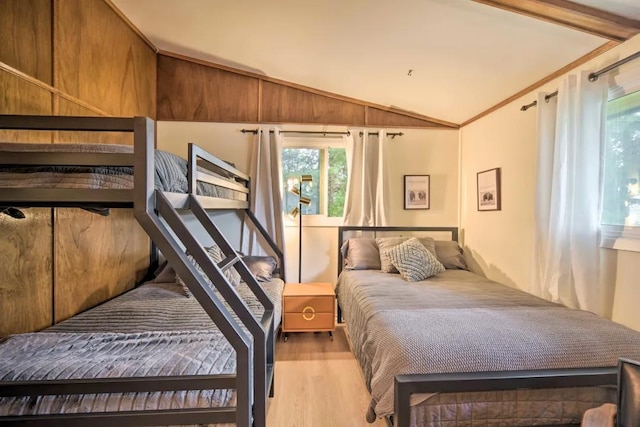 bedroom featuring vaulted ceiling, crown molding, and light wood-type flooring