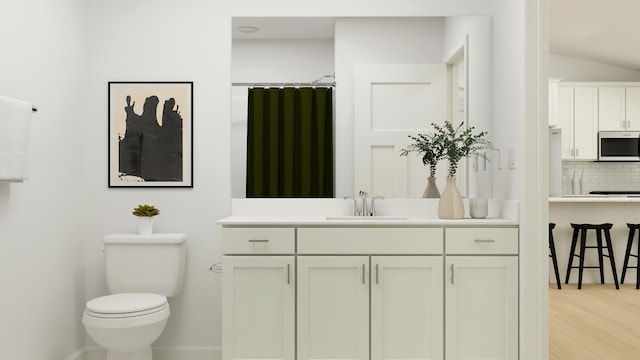 bathroom featuring tasteful backsplash, vanity, hardwood / wood-style floors, and toilet