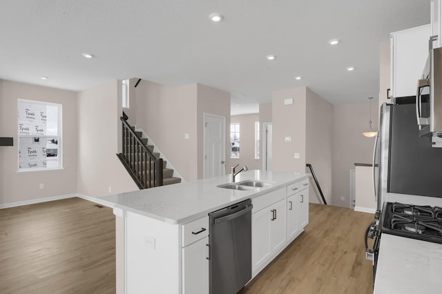 kitchen featuring sink, a center island with sink, white cabinets, and appliances with stainless steel finishes