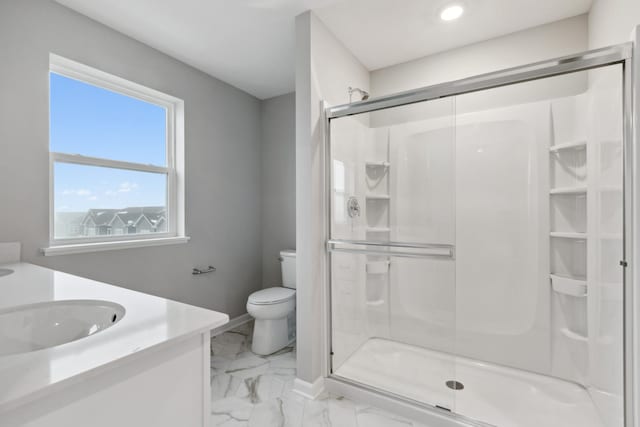 bathroom with vanity, a shower with shower door, and toilet