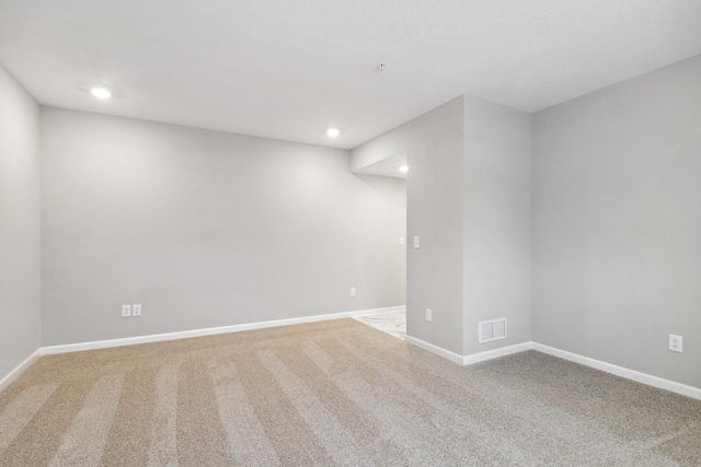 carpeted spare room featuring recessed lighting, visible vents, and baseboards