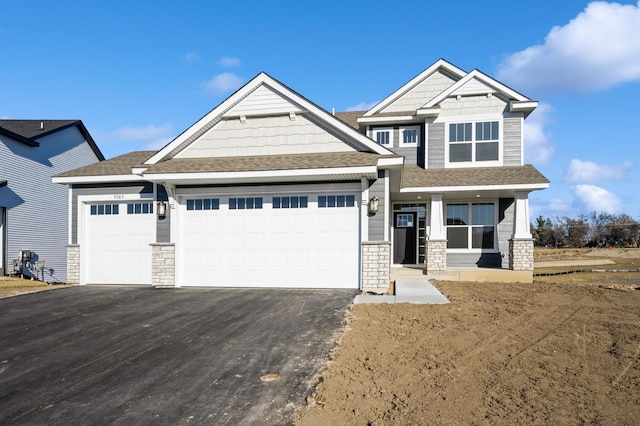 craftsman inspired home with a garage and covered porch