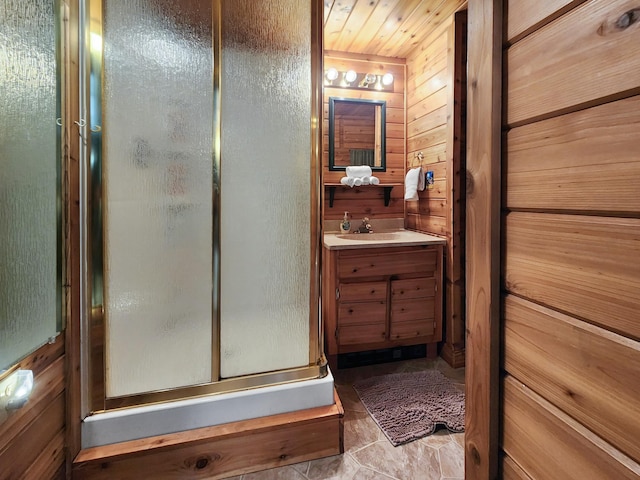 bathroom featuring an enclosed shower, vanity, and wooden walls