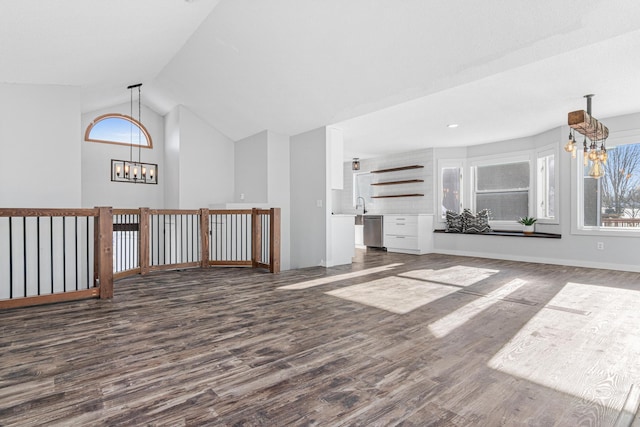 additional living space featuring a chandelier, high vaulted ceiling, a sink, baseboards, and dark wood finished floors