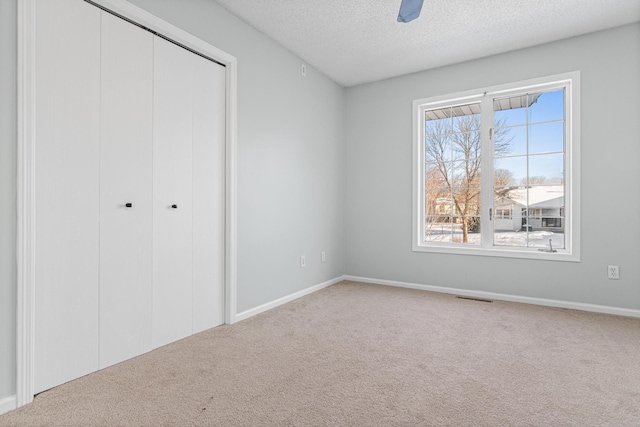 unfurnished bedroom with carpet, a closet, visible vents, and a textured ceiling