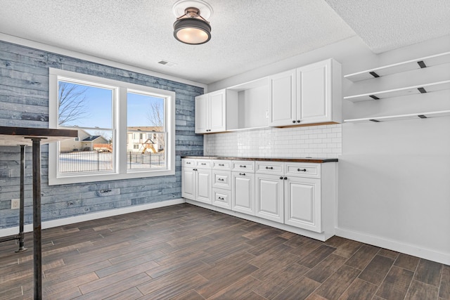 kitchen with dark countertops, white cabinets, dark wood finished floors, and open shelves