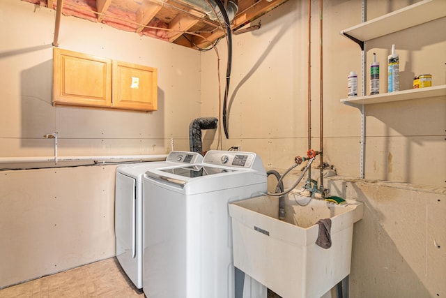 clothes washing area with laundry area, independent washer and dryer, and a sink