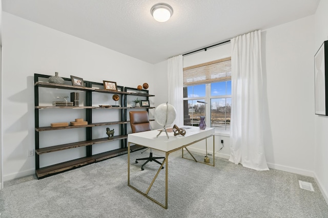 carpeted office space featuring a textured ceiling