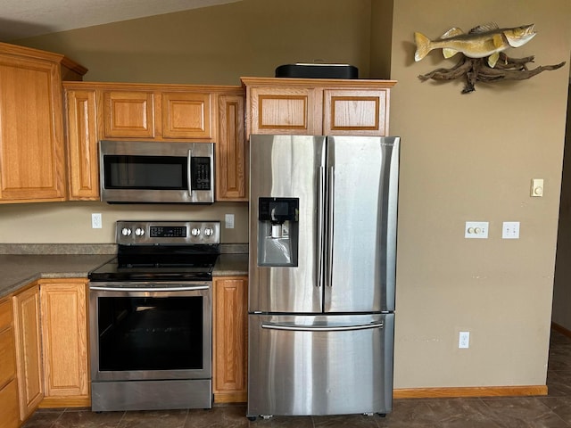 kitchen with vaulted ceiling and appliances with stainless steel finishes