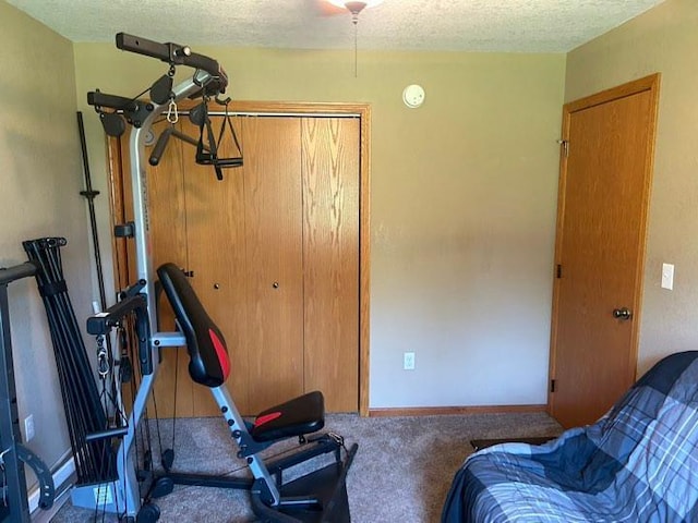 exercise room featuring carpet floors and a textured ceiling