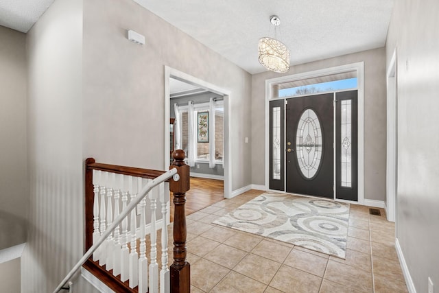 tiled entrance foyer featuring a textured ceiling