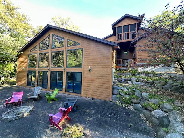 rear view of property with a patio area and an outdoor fire pit