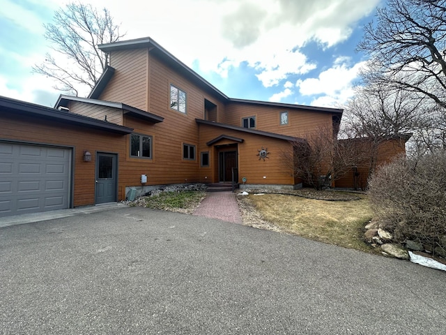 rustic home with an attached garage and driveway