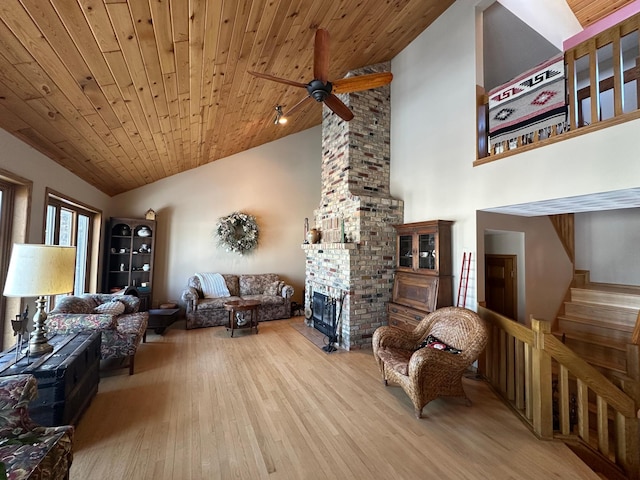 living area with wood finished floors, a brick fireplace, wood ceiling, and ceiling fan