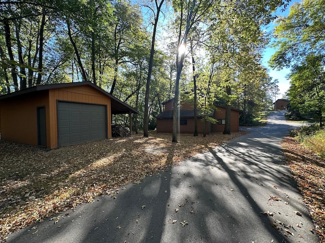 exterior space featuring driveway, an outbuilding, and a garage
