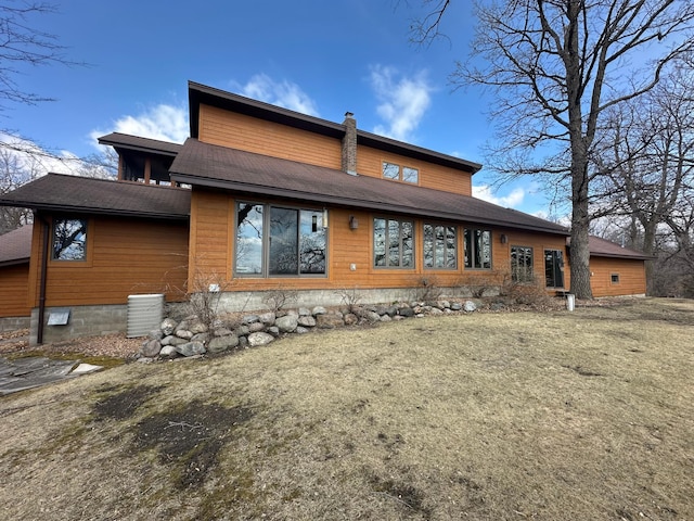 rear view of house featuring roof with shingles