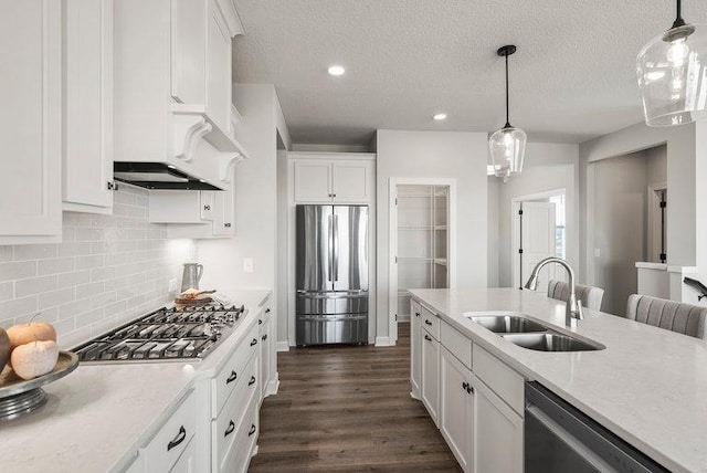 kitchen featuring white cabinetry, stainless steel appliances, decorative light fixtures, and sink