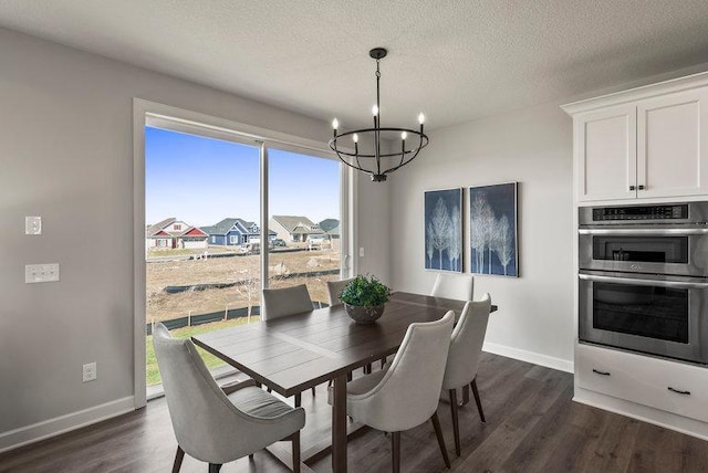 dining area with dark hardwood / wood-style floors, a textured ceiling, and a notable chandelier