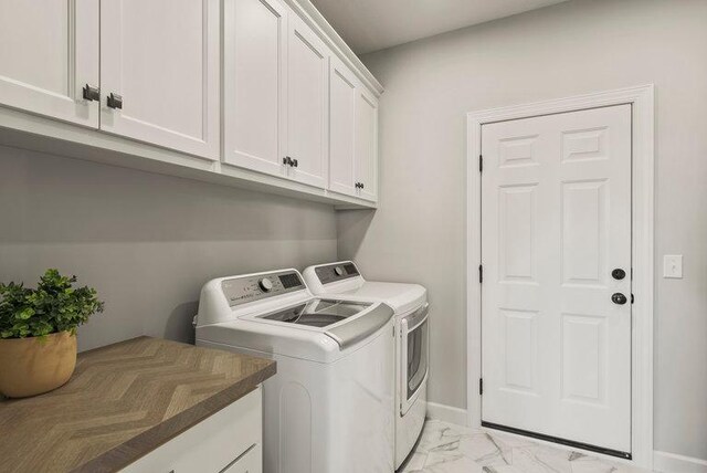 clothes washing area with cabinets and independent washer and dryer